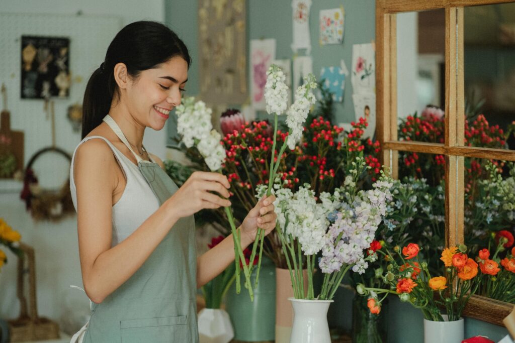 A flower shop owner checks the scent of her merchandise. 