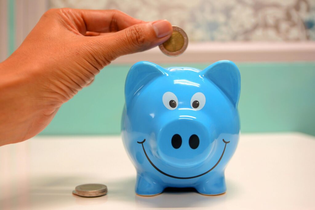 Dropping a coin daily for savings in a piggy bank.